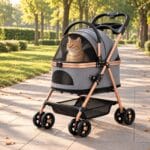 Orange tabby cat sitting up and looking out through the mesh hood of a gray cat stroller on a park avenue