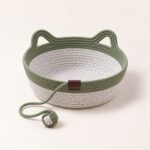 snugweave-rope-cat-basket-green Sage green rope cat basket with a speckled gray body, cat-ear handles and a green rope ball, on cream