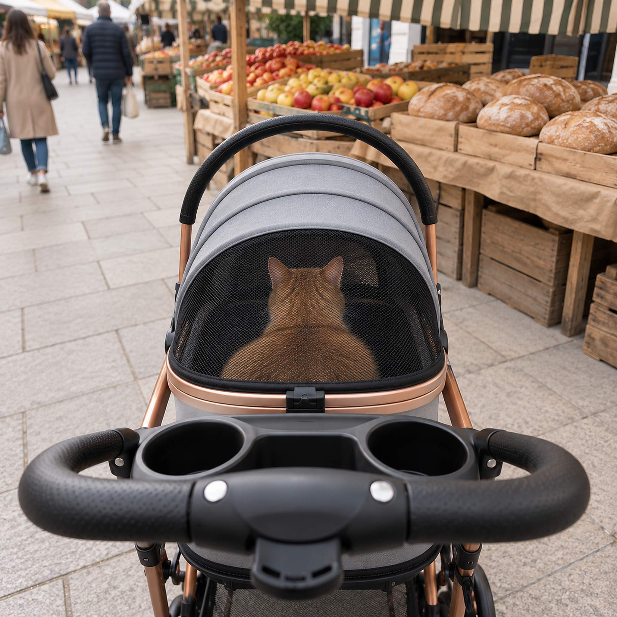 Orange tabby cat watching a market street from inside the mesh hood of a gray cat stroller
